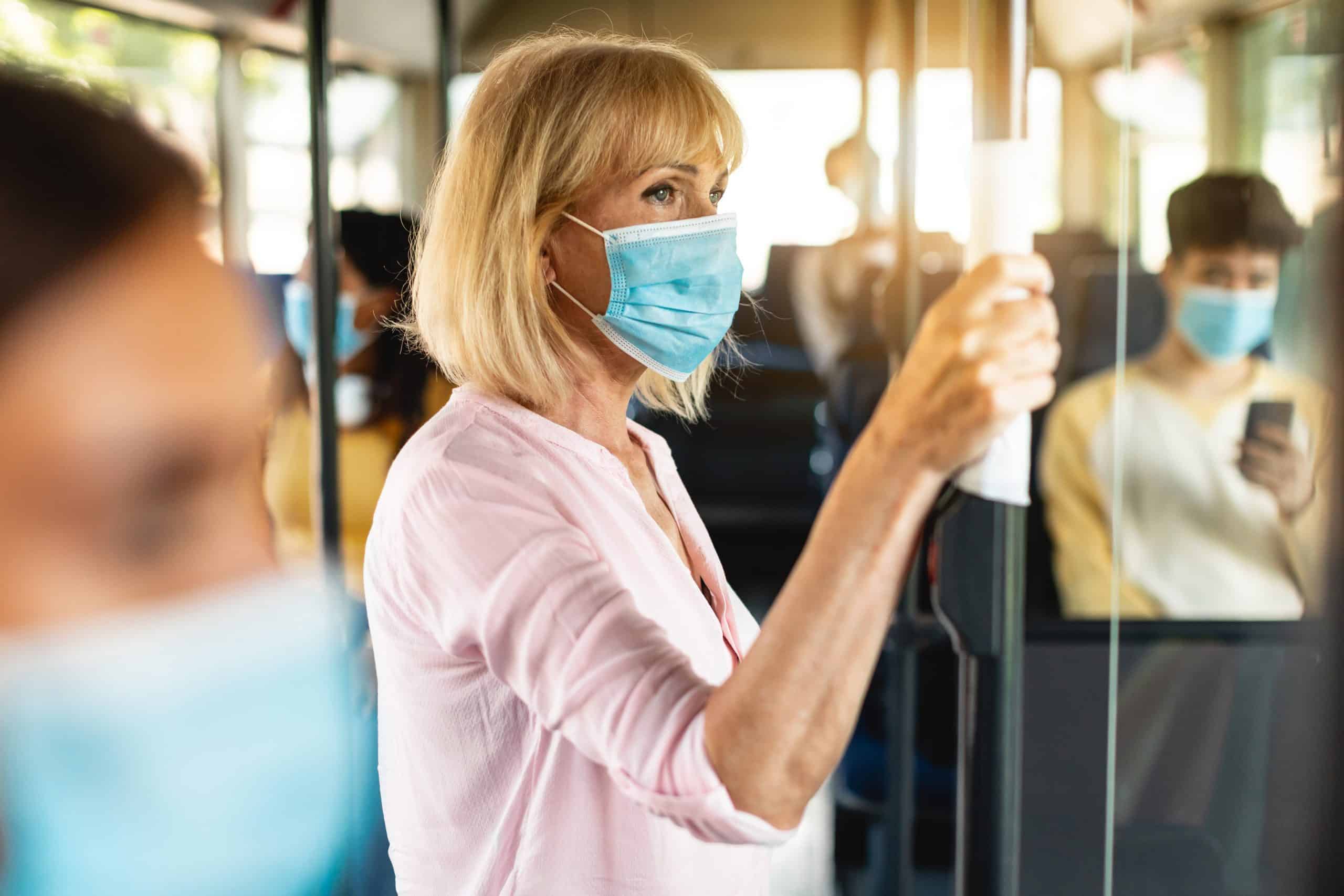 A woman wearing a medical mask on a bus A woman wearing a medical mask on a bus